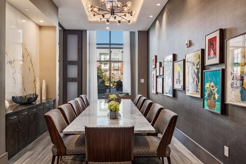 A dining room with a long table and chairs.