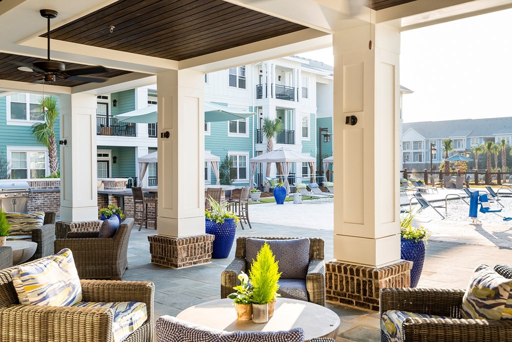 A patio with a table and chairs is surrounded by buildings at Wharf 7 Apartments, Charleston, South Carolina