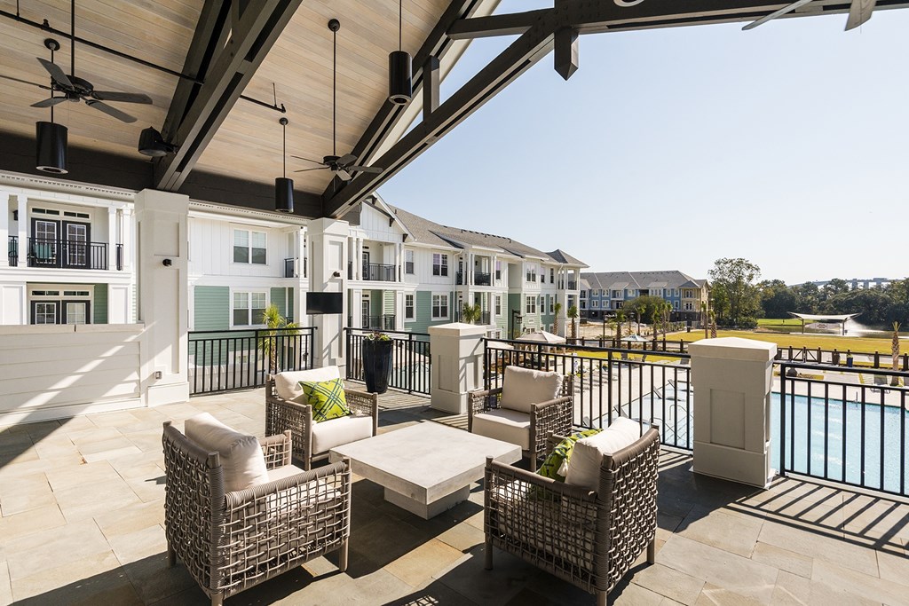 A patio with a table and chairs overlooking a pool at Wharf 7 Apartments, South Carolina 29492