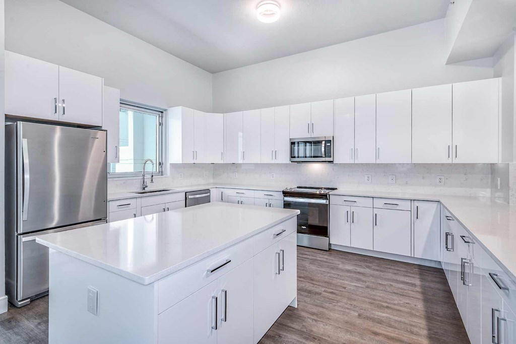 an all white kitchen with white cabinets and stainless steel appliances at Paramount on Lake Eola, Orlando, 32801