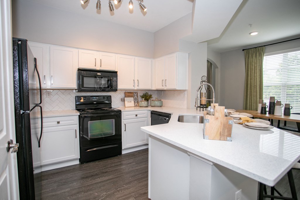 Kitchen with counter seating at Emblem Alpharetta, Alpharetta, 30009