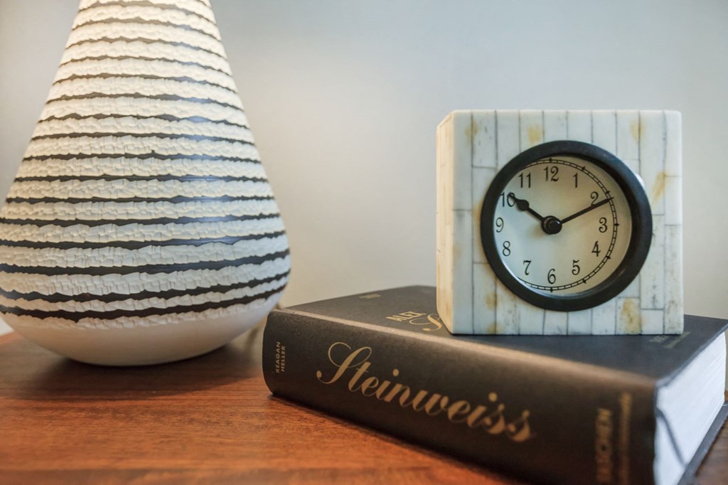 bedside table with book, clock and vase at The Canyons at Linda Vista Trail, Oro Valley, Arizona