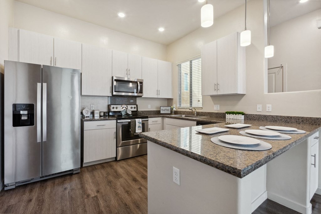 a kitchen with white cabinets and stainless steel appliances at Pima Canyon, Tucson, AZ