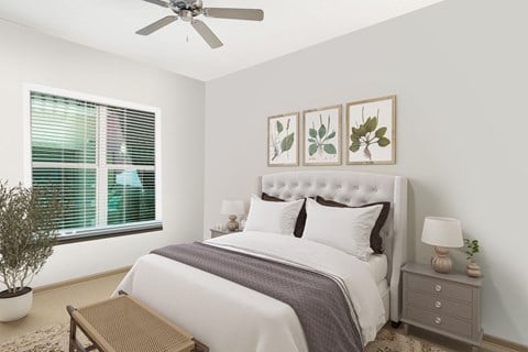 a bedroom with white walls and a large window with blinds at The Rialto, Orlando
