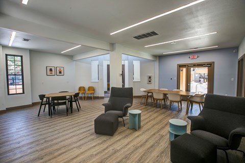A room with wooden floors and furniture including a table and chairs.