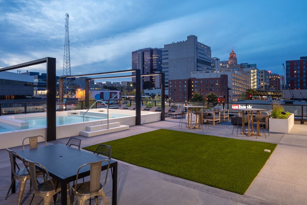 a rooftop patio with a pool and cityscape in the background at Maven on Broadway, Rochester, MN, 55904