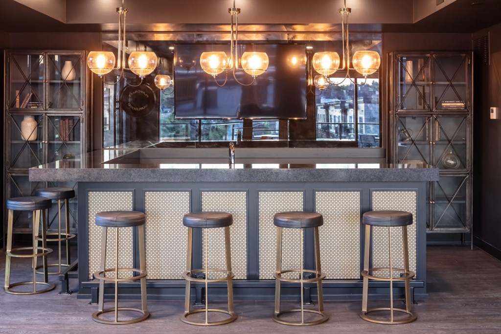 a bar with stools and a television at Maven on Broadway, Rochester, Minnesota