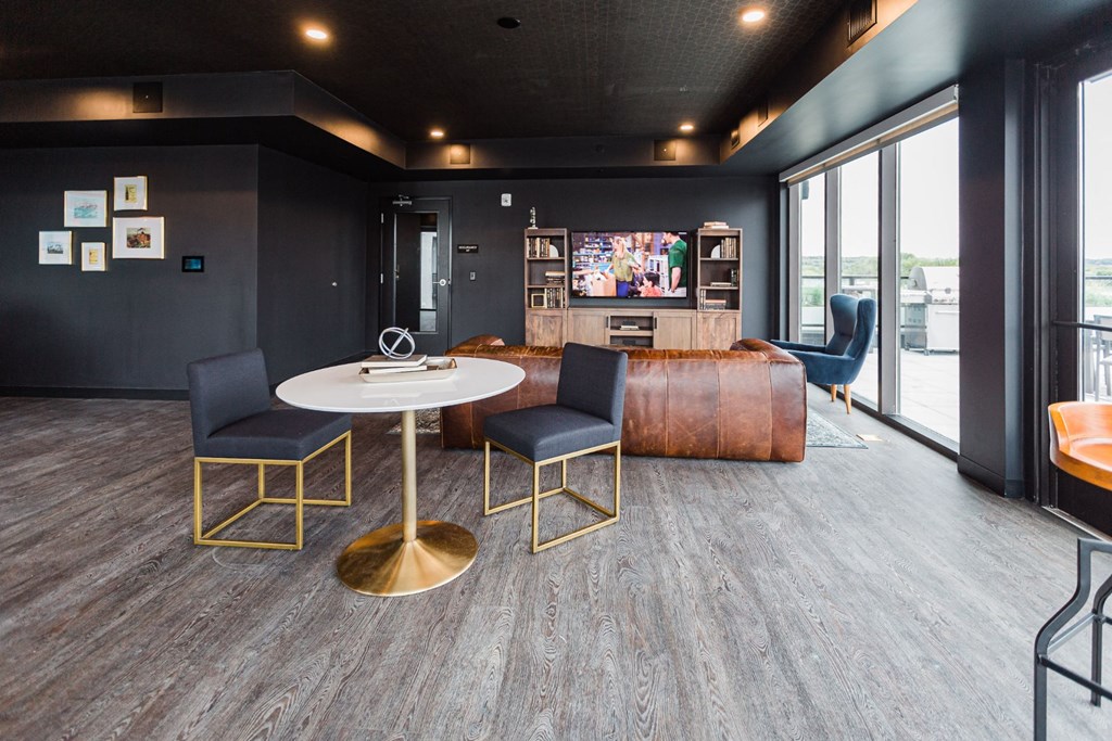 a lounge area with a table and chairs and a large window at Maven on Broadway, Minnesota, 55904