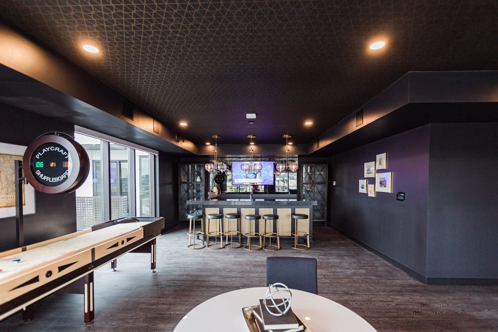 a bar in the clubhouse with a mirrored wall, tables and chairs at Maven on Broadway, Minnesota