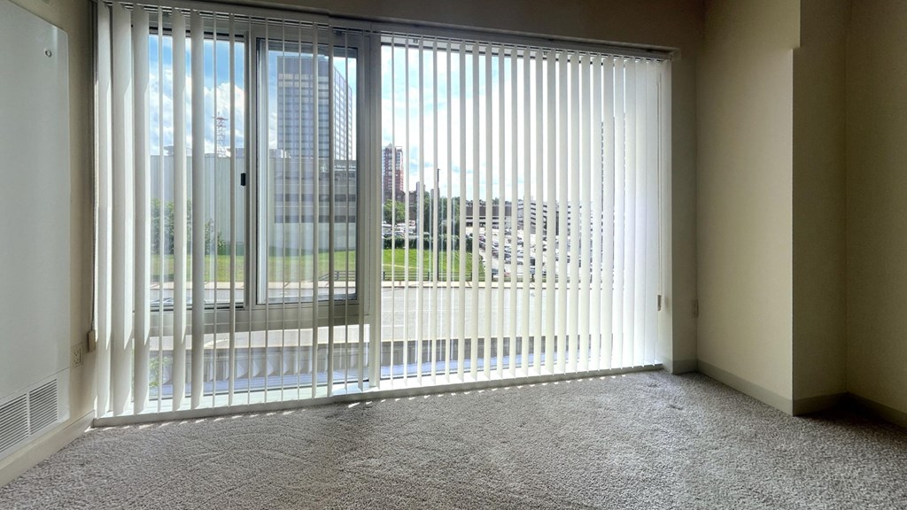 a living room with a large window with white blinds