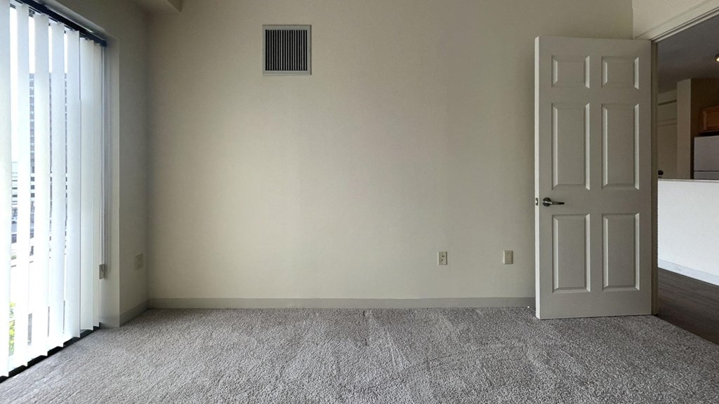 an empty room with a door and a carpeted floor