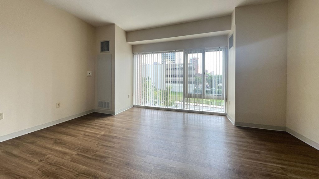 an empty living room with wood floors and a sliding glass door