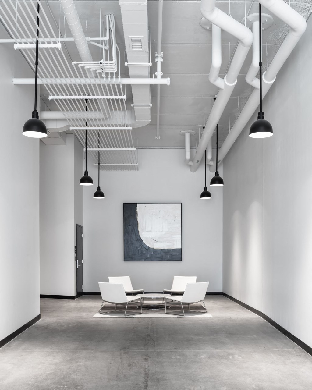 a conference room with white chairs and a table and ceiling lights at Maven on Broadway, Rochester, MN, 55904