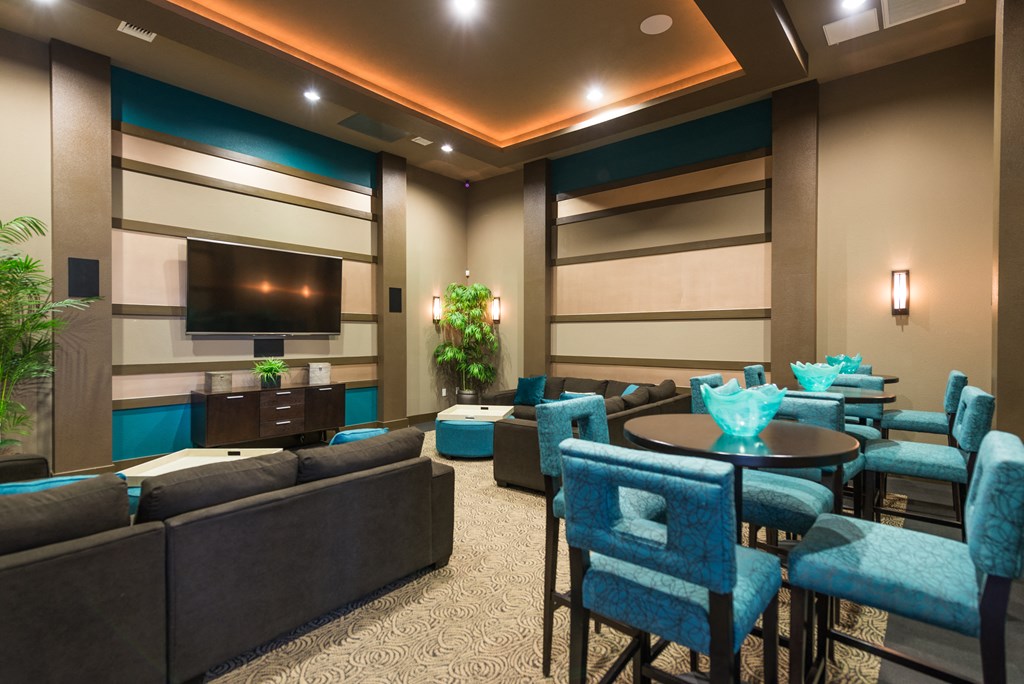 a lounge area with blue chairs and couches and a television at Estate at Woodmen Ridge, Colorado