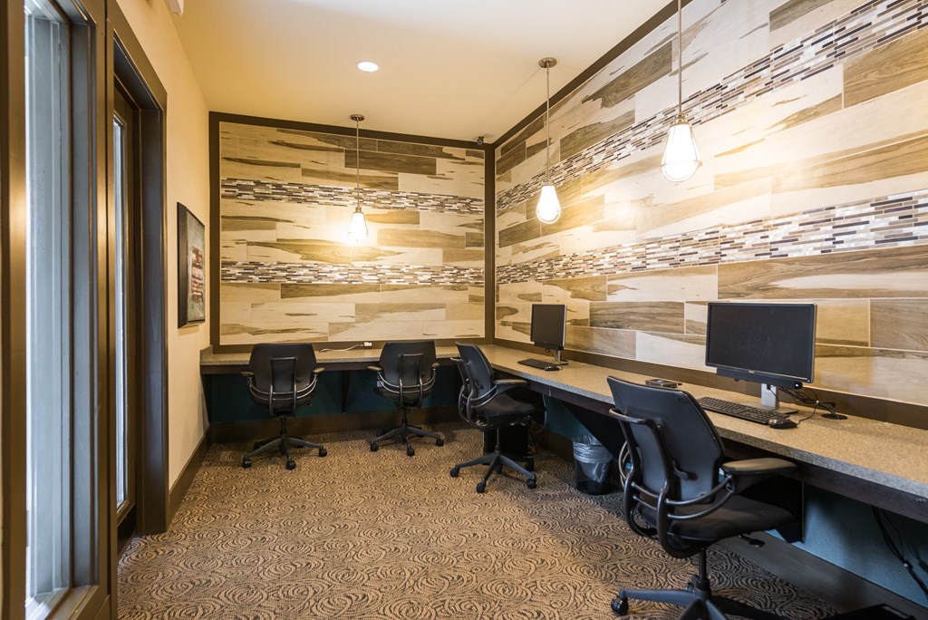 a conference room with desks and chairs and a wall of wood paneling at Estate at Woodmen Ridge, Colorado Springs