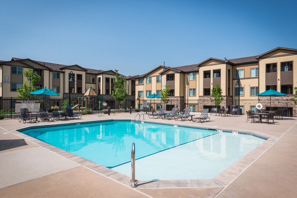 a swimming pool with an apartment building in the background at Estate at Woodmen Ridge, Colorado
