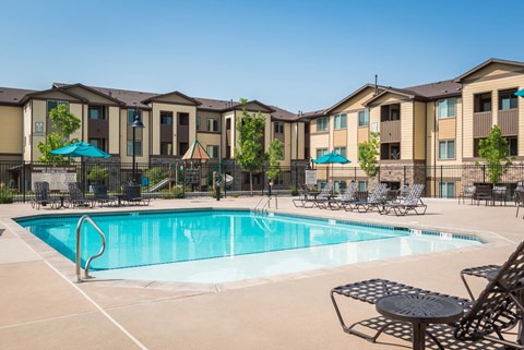 our apartments have a swimming pool with chairs and umbrellas at Estate at Woodmen Ridge, Colorado Springs, CO 80923