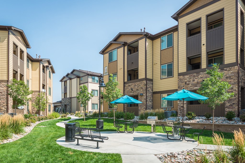 our apartments have a patio with umbrellas and tables at Estate at Woodmen Ridge, Colorado Springs, CO