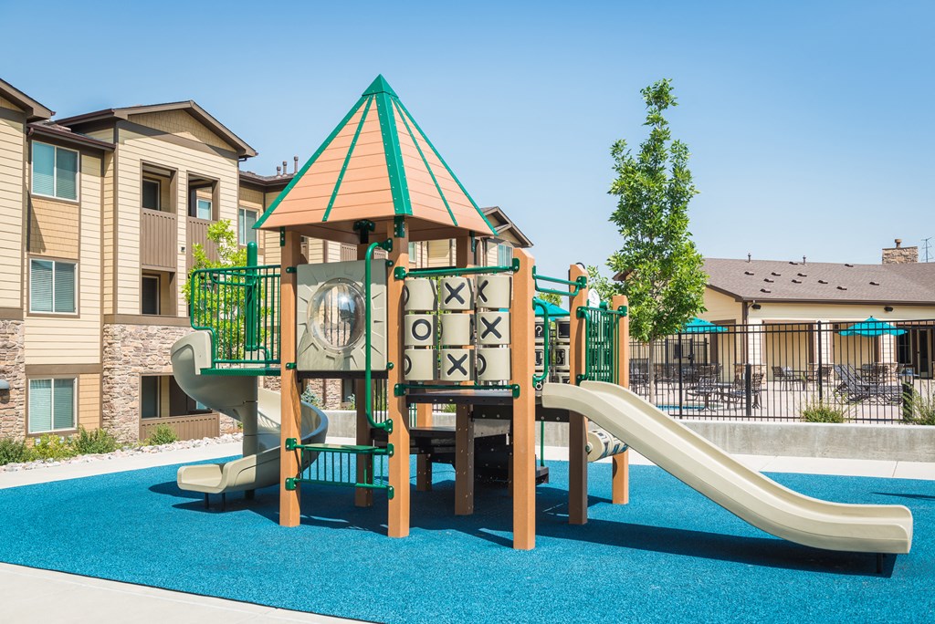 a childrens playground with slides in front of a house at Estate at Woodmen Ridge, Colorado Springs
