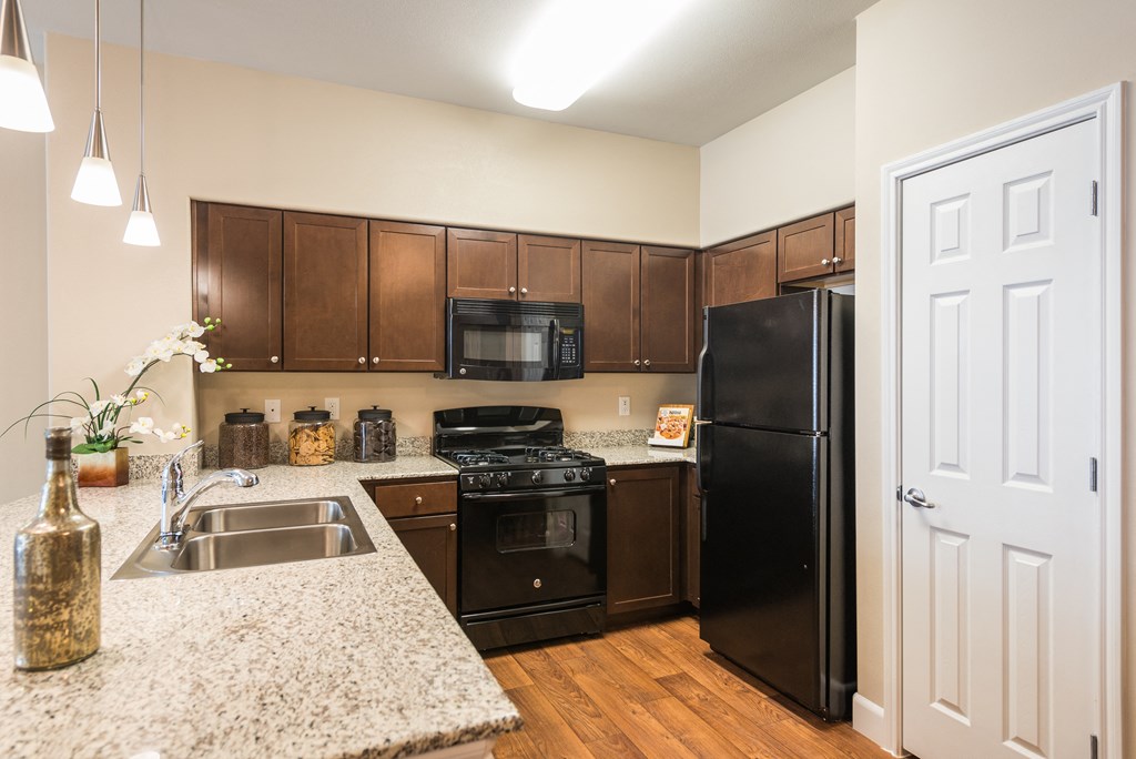 a kitchen with black appliances and granite counter tops at Estate at Woodmen Ridge, Colorado