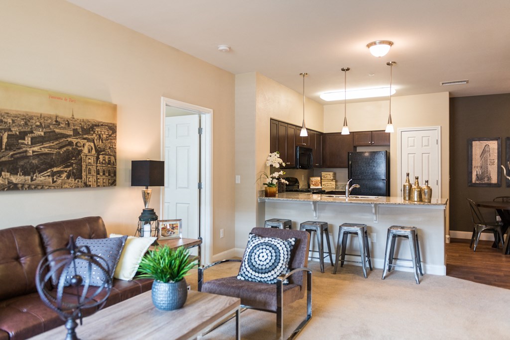 a living room with a couch and a kitchen with a bar at Estate at Woodmen Ridge, Colorado Springs, 80923