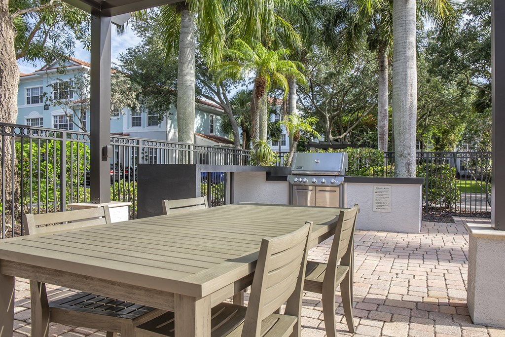 A wooden table and chairs are set up on a patio.
