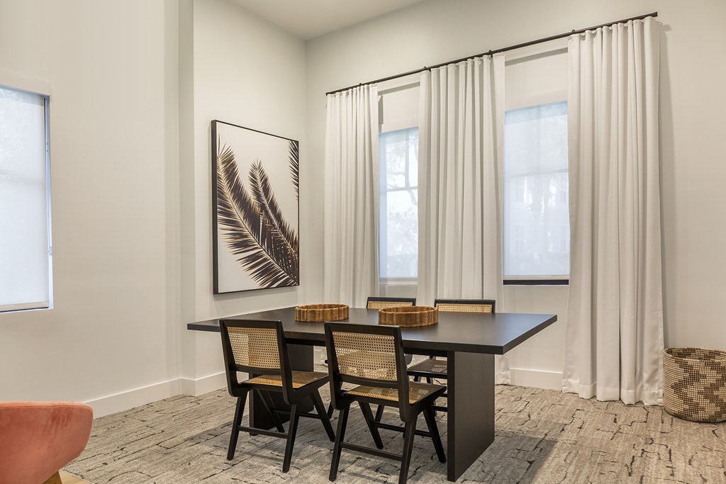A room with a black table and chairs at the clubhouse l at Floresta apartments in Jupiter, FL