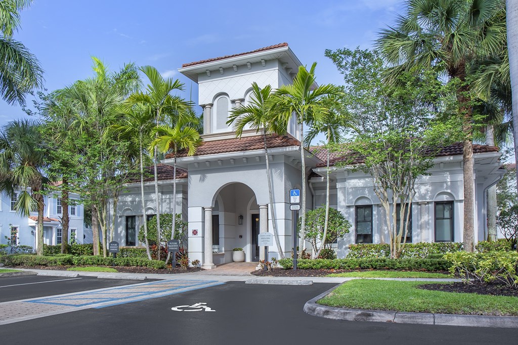 A white building with a blue sign in front of it.