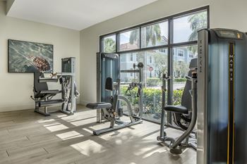 A gym with a treadmill, weights, and exercise equipment at Floresta, Jupiter, 33458