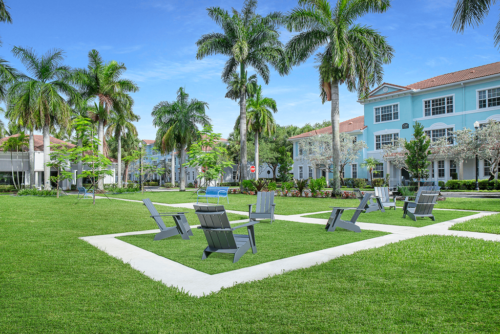 A park with benches and palm trees at Floresta apartments in Jupiter, FL