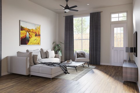 A living room with a large couch, a painting on the wall, and a ceiling fan.