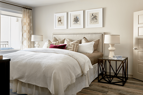 A bedroom with a large bed and a window with curtains.