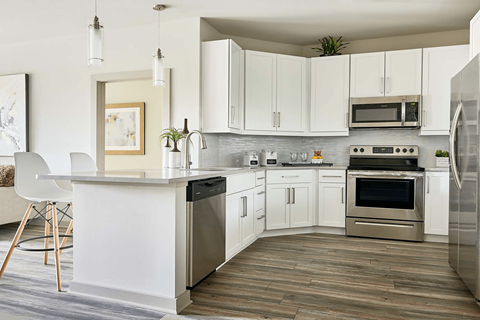 A modern kitchen with white cabinets and stainless steel appliances.