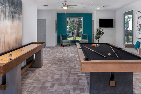 A room with a pool table and a tv.