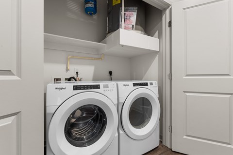 A Whirlpool washing machine is sitting in a small laundry room.