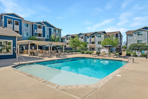 A swimming pool in front of apartment buildings.