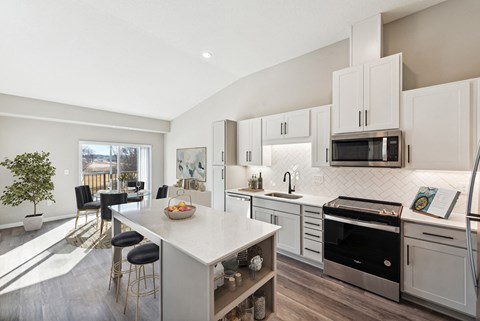 A modern kitchen with white cabinets and a large island.