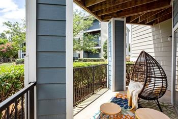 A balcony with a chair and a table.