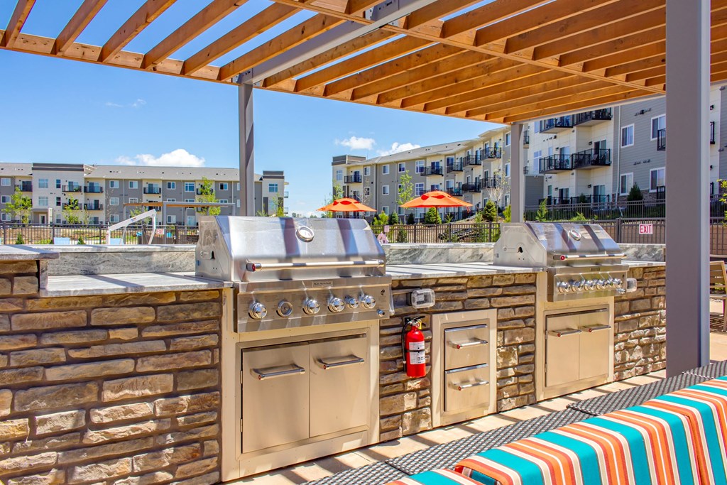 an outdoor kitchen with stainless steel appliances and a pergolaat SoRoc On Maine, Minnesota, 55904