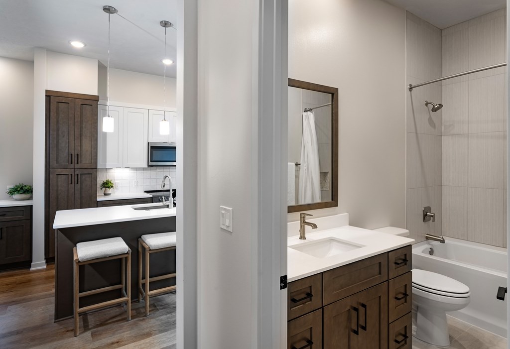 A bathroom with a sink, toilet, and a mirror.