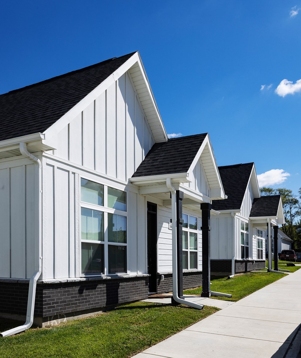 A series of white houses with black roofs and windows.