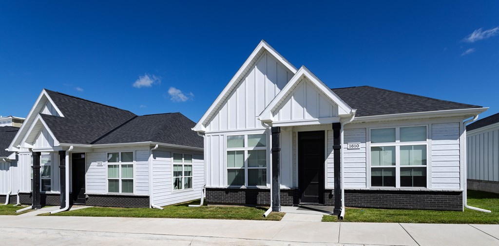 A white house with a black roof and a black door.