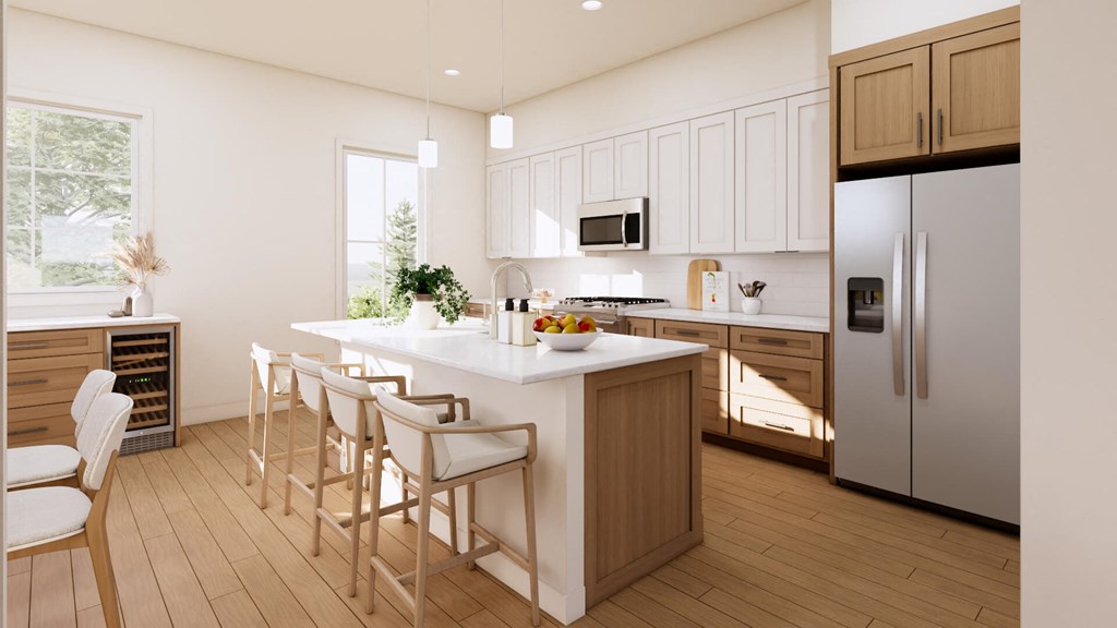 a kitchen with a center island and a stainless steel refrigerator