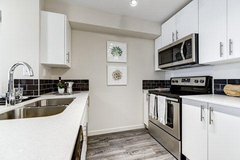 A kitchen with white cabinets and a black stove top oven.