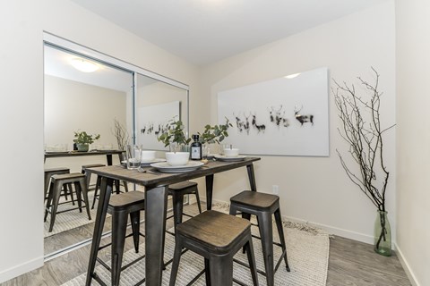 A dining room with a table and chairs.