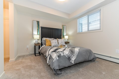 A bedroom with a large bed and two lamps on either side of it.