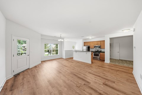 A spacious room with wooden flooring and white walls.