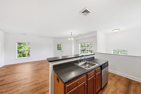 A kitchen with a black countertop and wooden cabinets.