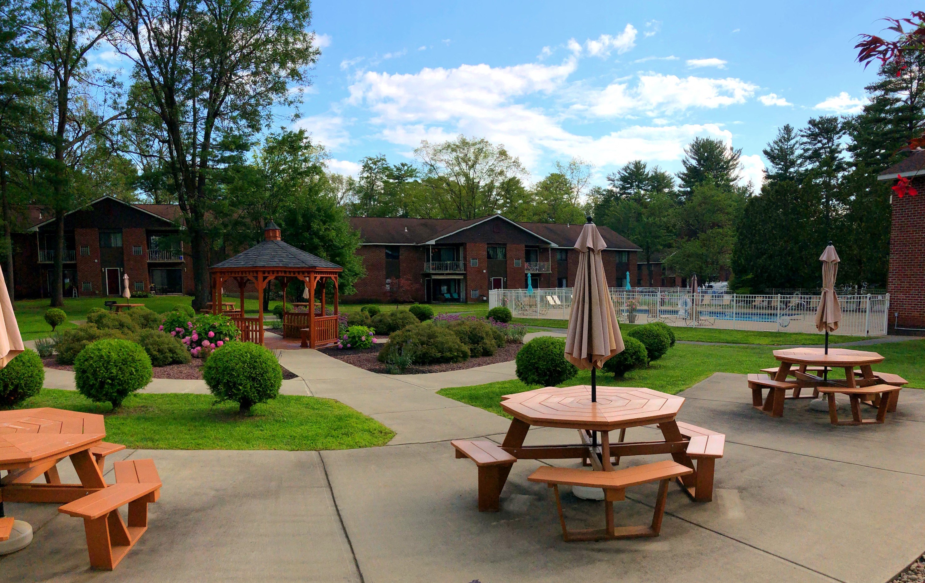 a patio with tables and benches in front of a building