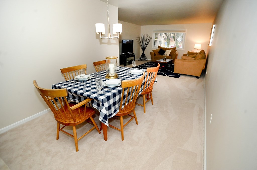 a dining room table with wooden chairs and a checkered table cloth